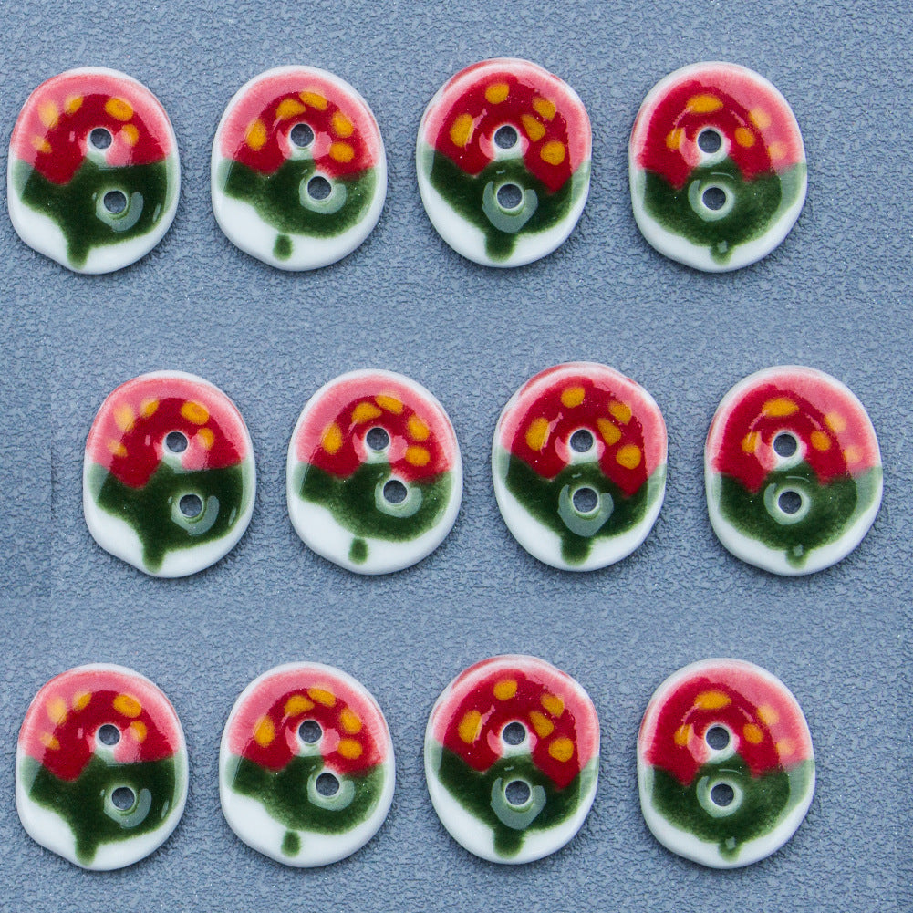 Four oval ceramic buttons with red-green strawberry pattern, each with two holes