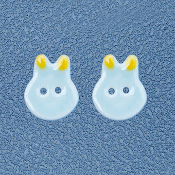 Light blue ceramic bunny rabbit sewing buttons, 2-hole, yellow ears, pair view