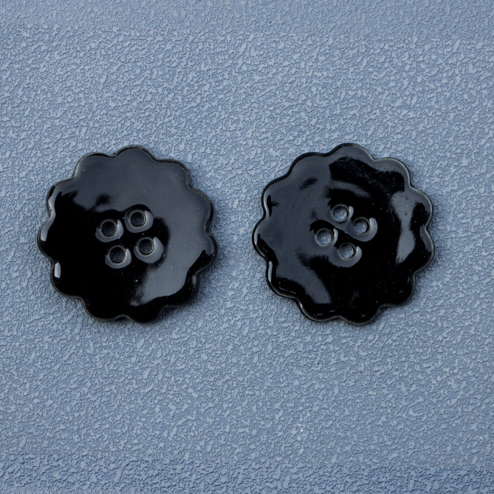 30mm round ceramic buttons, four-hole, black lace-edged, pair close-up