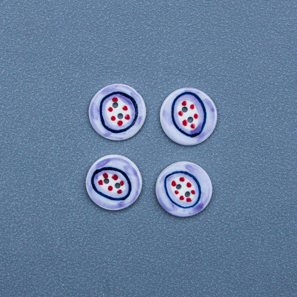 Two-hole porcelain button, light purple edge, blue-and-white center with red dots