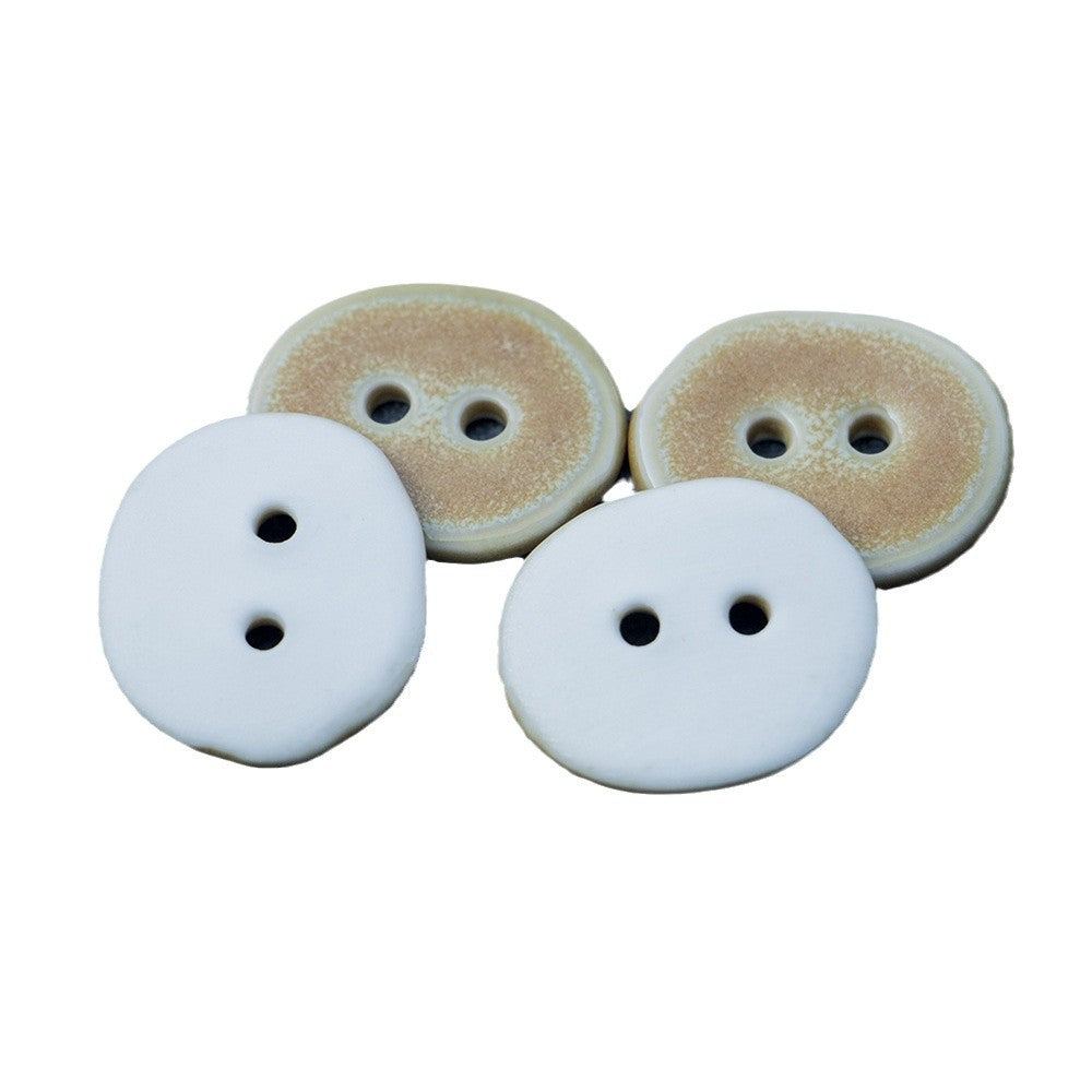 Irregular oval ceramic buttons, two-hole; sand front with pale back pieces