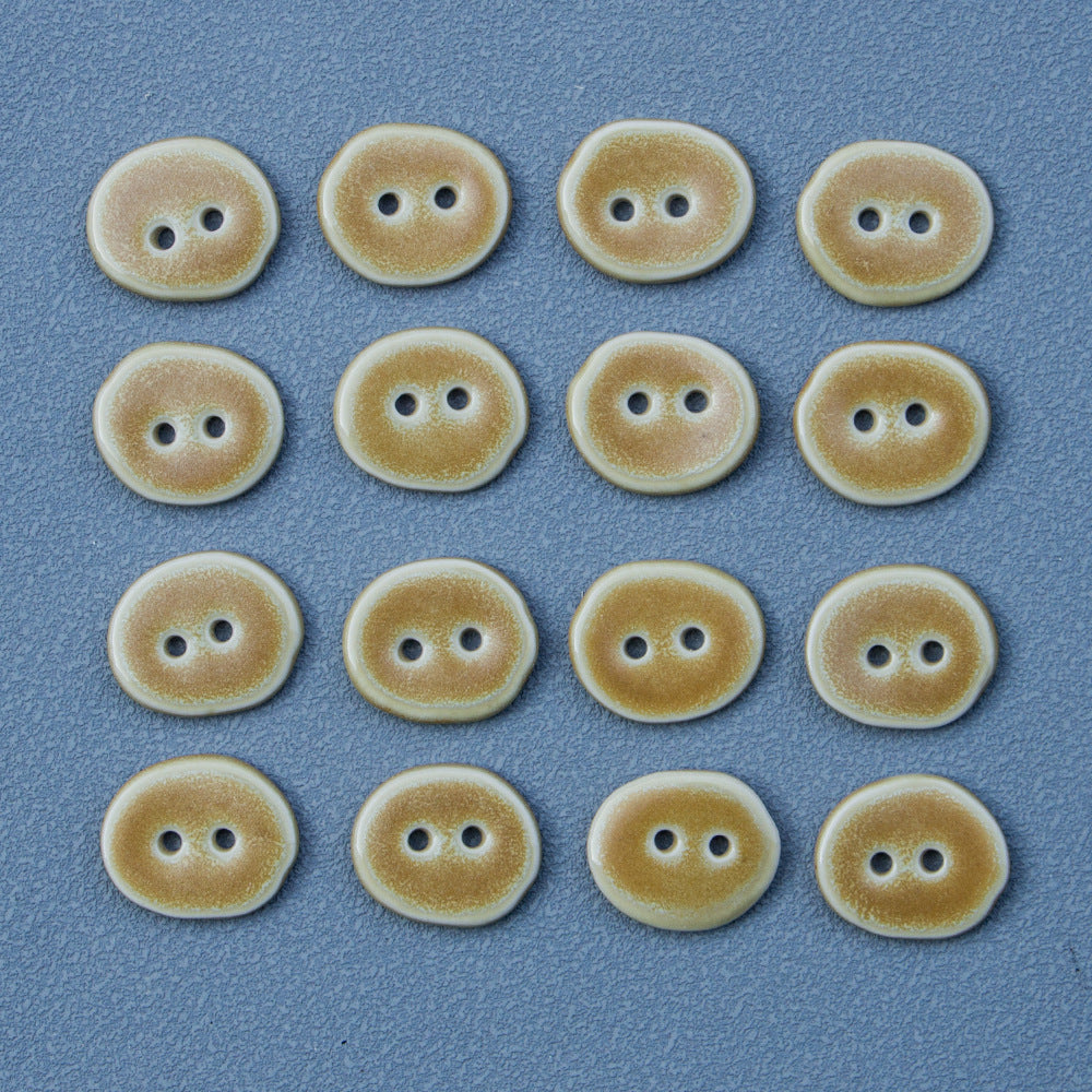 Multiple sand-colored irregular oval ceramic buttons, each with two holes
