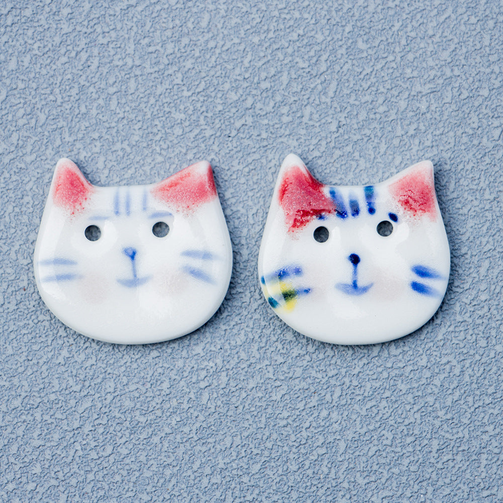 Blue and white cat ceramic button with red ears, pointed cat-face shape