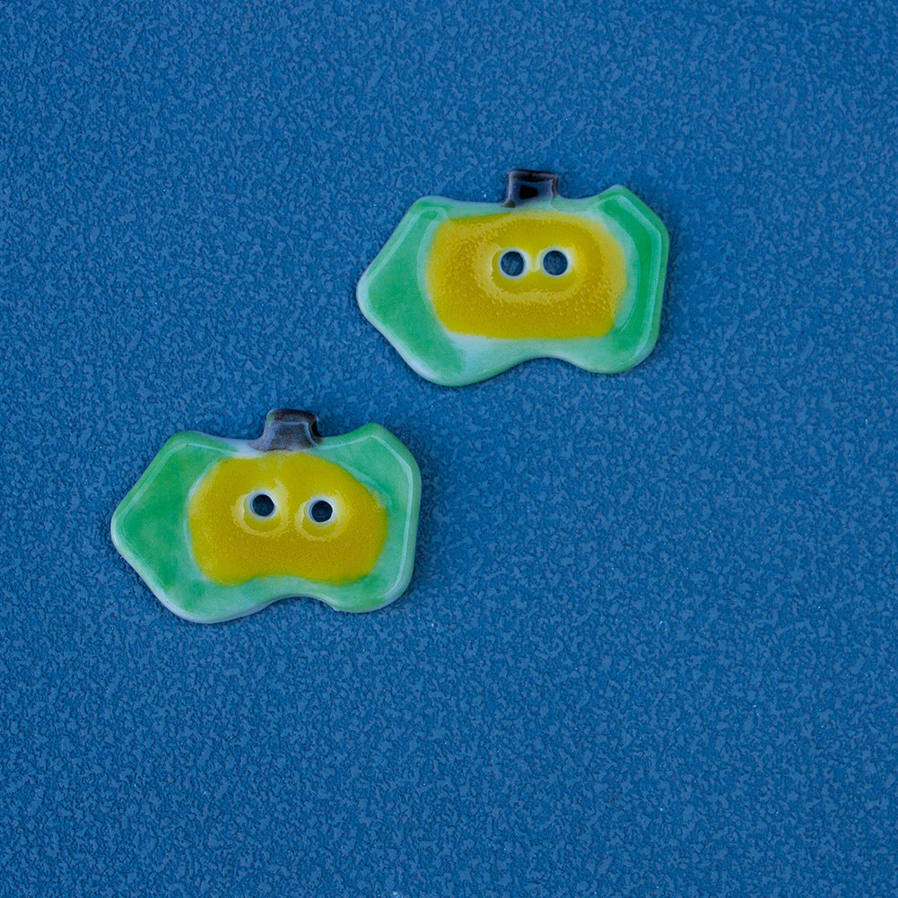 Ceramic apple button with green rim and yellow face with two holes (Style D)