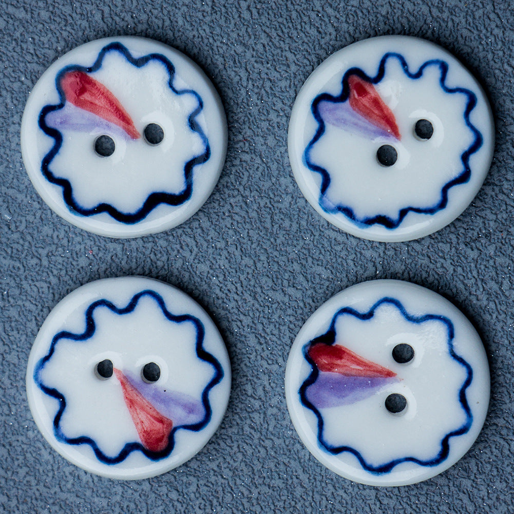 Two blue-and-white ceramic 2-hole buttons with red center petal design