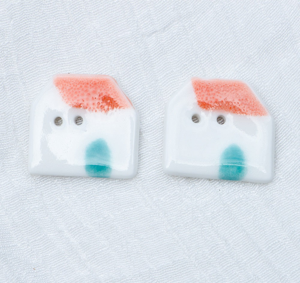 Ceramic house buttons, white with orange tiled roof, blue window shapes, two-hole face