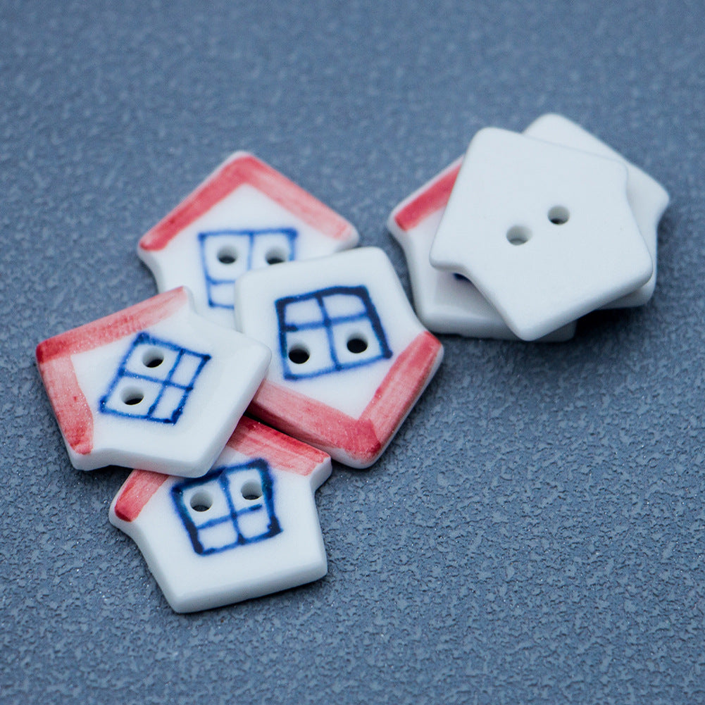 Ceramic house buttons with red roofs; one shows plain backside with 2 holes