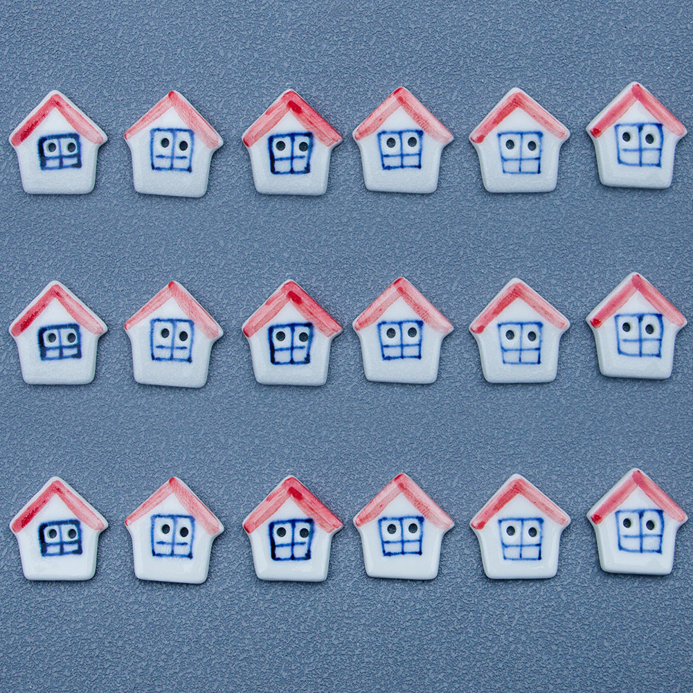 Small ceramic house buttons with red roofs and blue faces, assorted arrangement