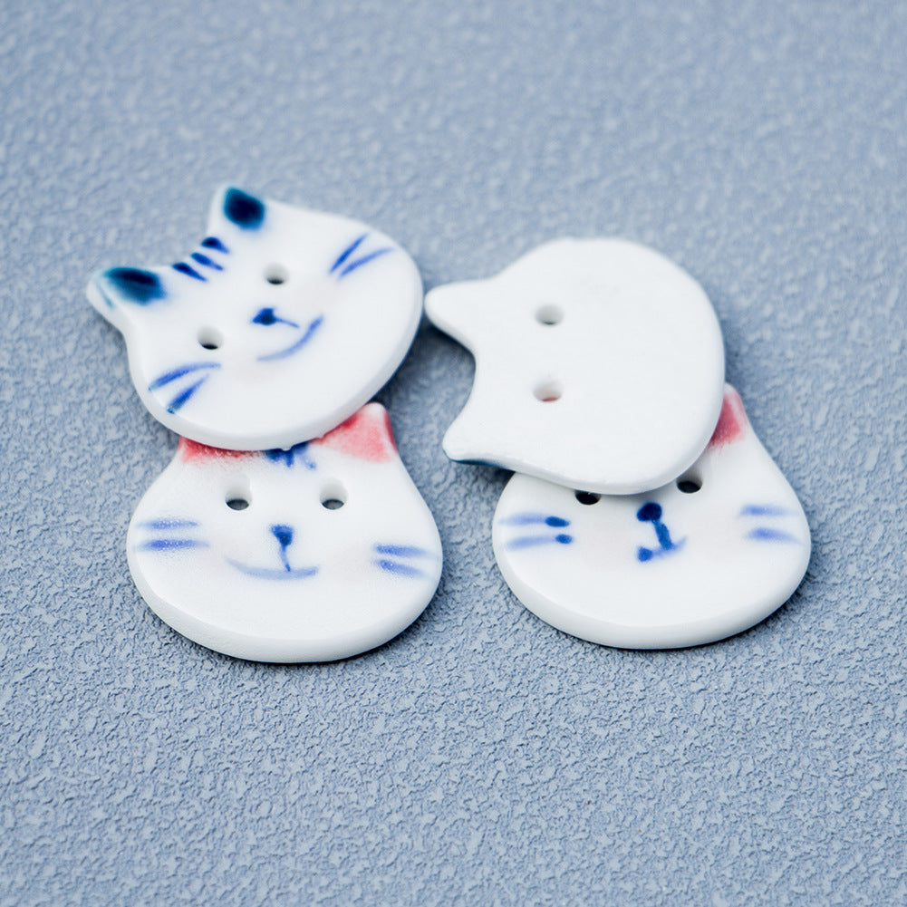 Cat ceramic buttons with blue and red/pink ears, white faces with blue whiskers
