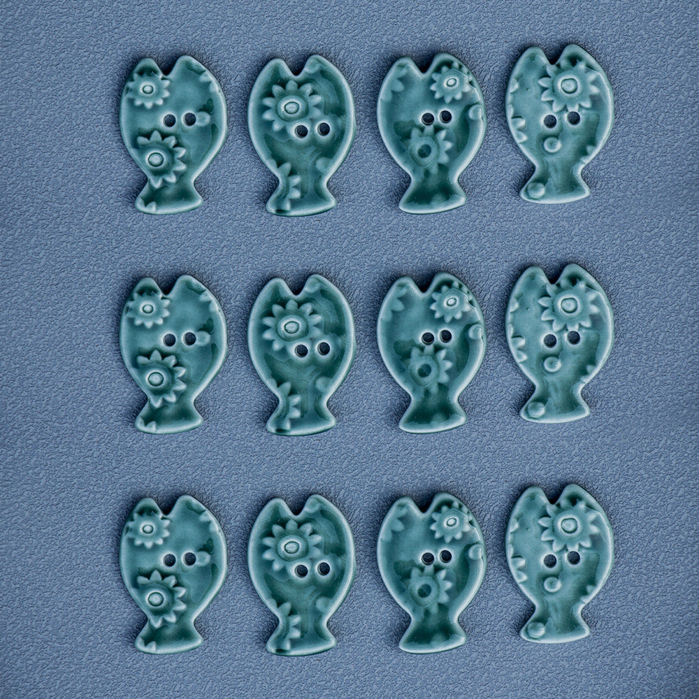 Nine fish-shaped ceramic DIY buttons in green moss, each with 2 holes and textured detailing.