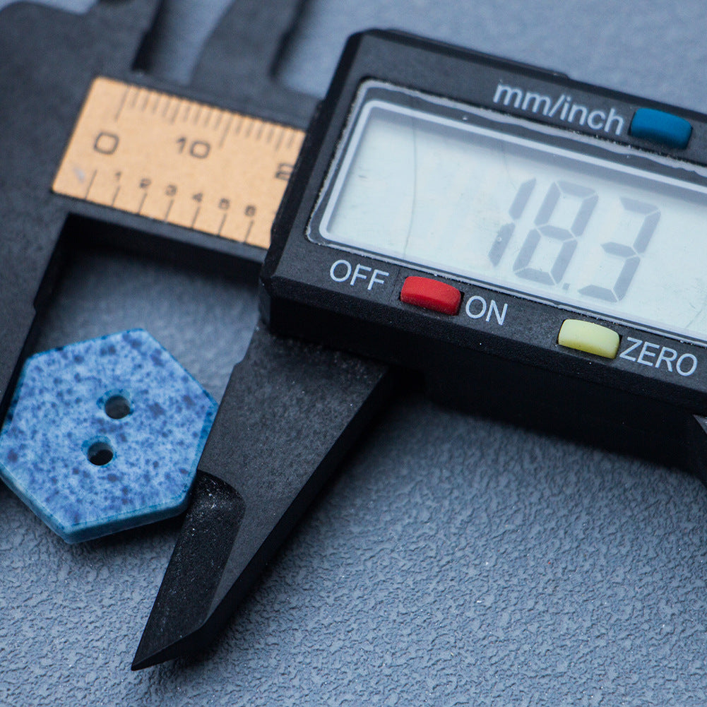 Navy blue hexagonal 2-hole ceramic button next to gauge showing about 18mm