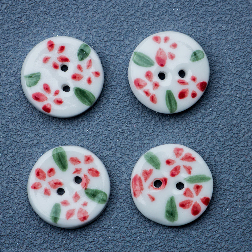 Handmade ceramic button, white with red floral design and green leaves, 2-hole round