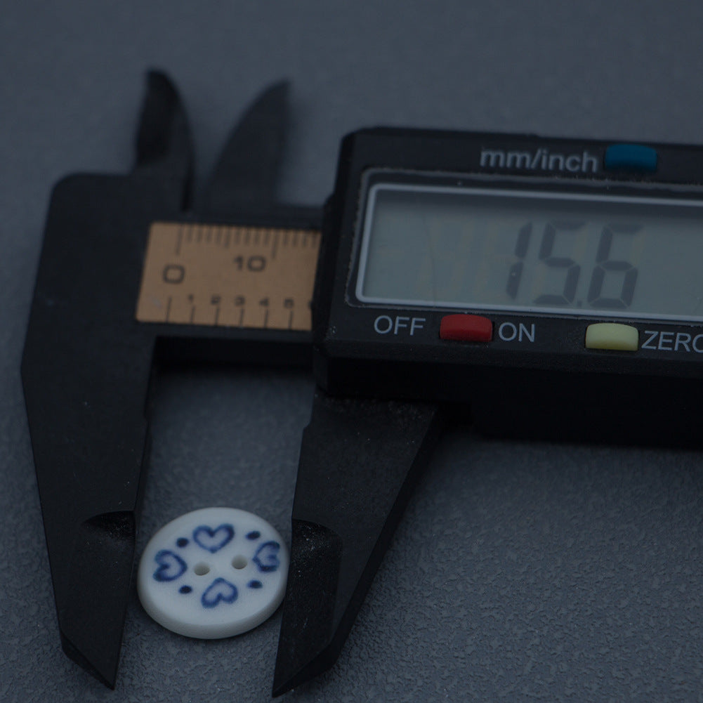 15.6mm round blue-and-white porcelain heart ceramic button shown with caliper measurement