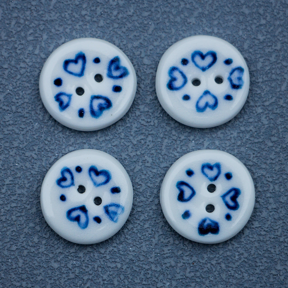 Porcelain heart ceramic button pair, blue heart motifs on white surface with shank holes