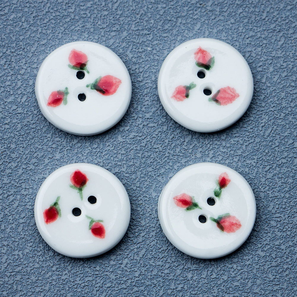 Four round ceramic buttons with hand-painted strawberry pattern and two holes.