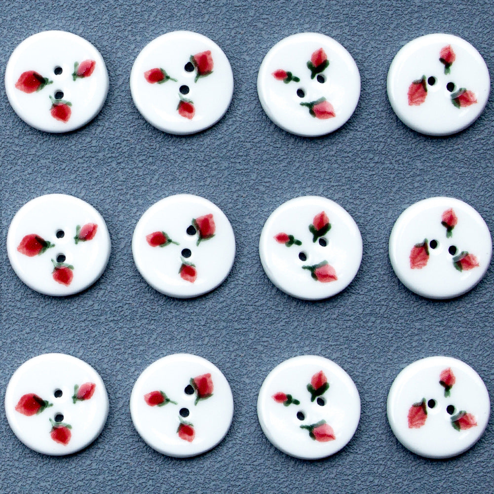 Set of round ceramic buttons with three strawberry motifs and two-hole design.