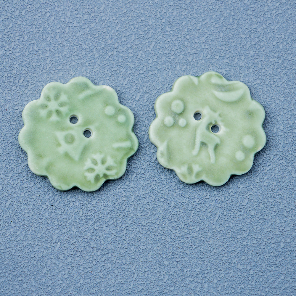 Round ceramic 2-hole buttons with snowflake elk motif in light green (2 pcs)