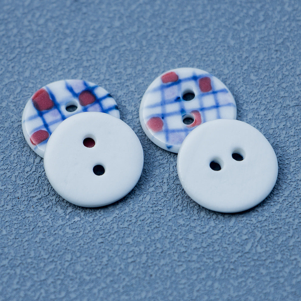 Round ceramic 2-hole buttons in blue plaid pattern with red squares and black holes (2)