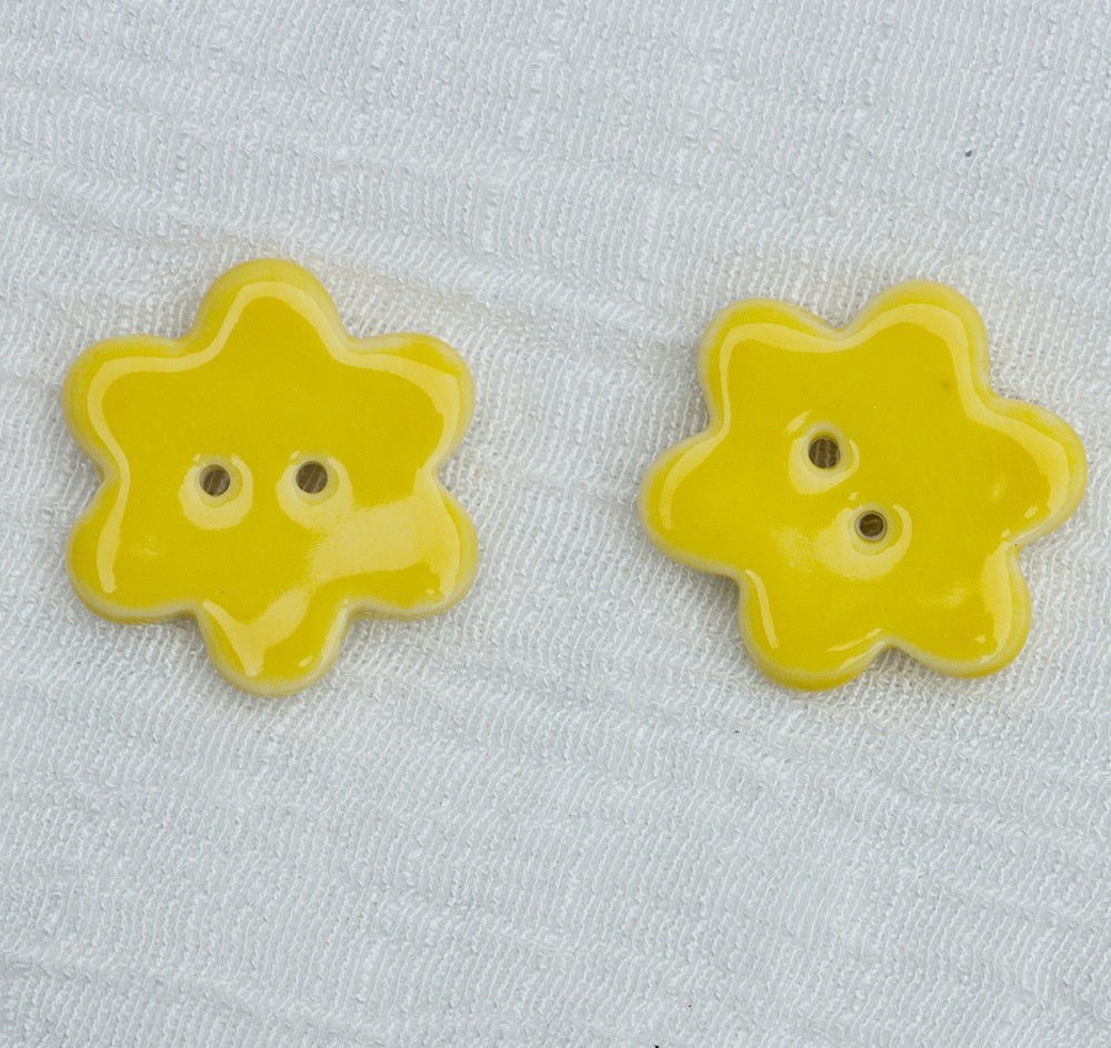 Yellow ceramic flower buttons with two holes, pair view