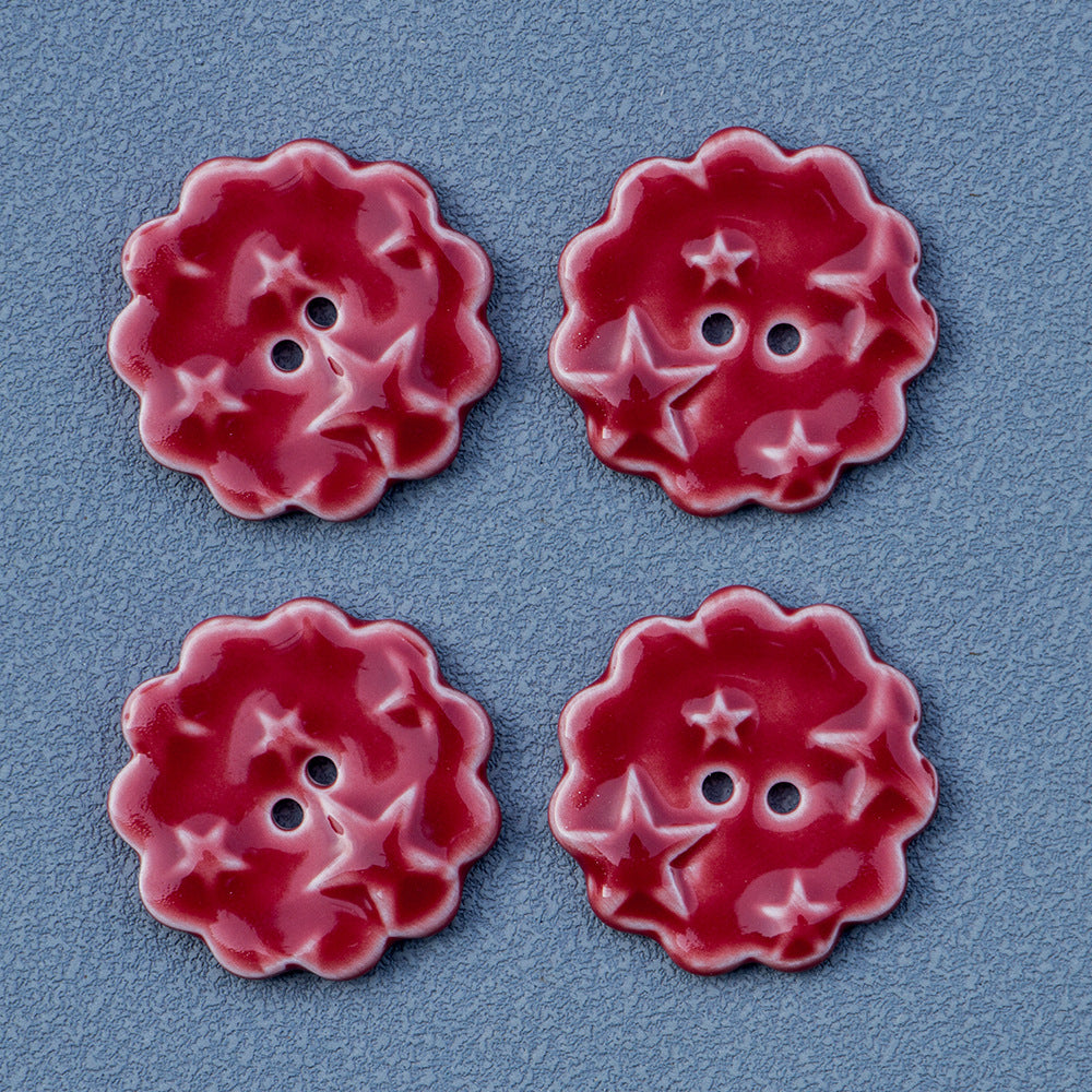 Set of red round ceramic buttons with star pattern and two holes