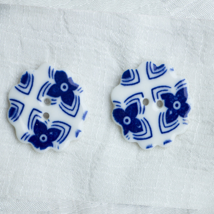 30mm ceramic two-hole flower buttons with blue motifs on white (2 pcs)