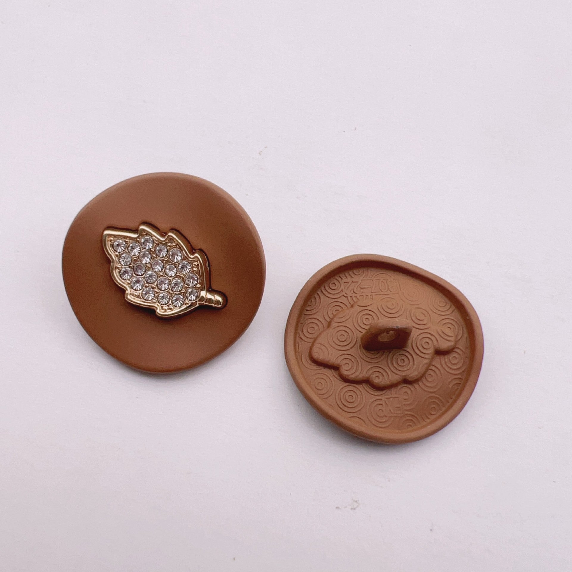Brown arched jeweled button with gold leaf trim and rhinestone leaf design