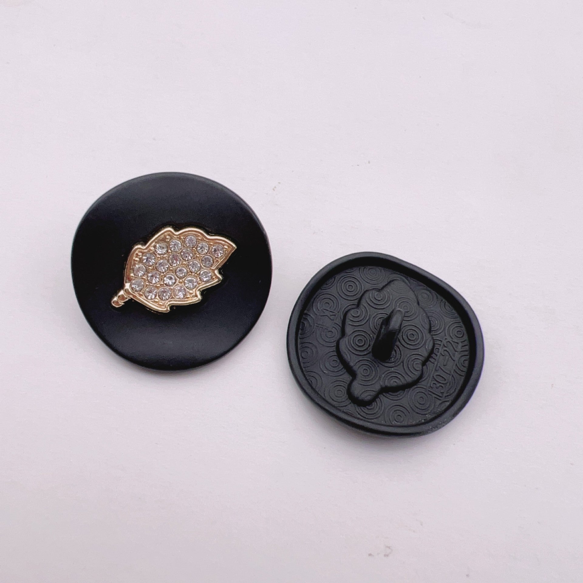 Black arched jeweled button with gold leaf trim and rhinestone leaf design