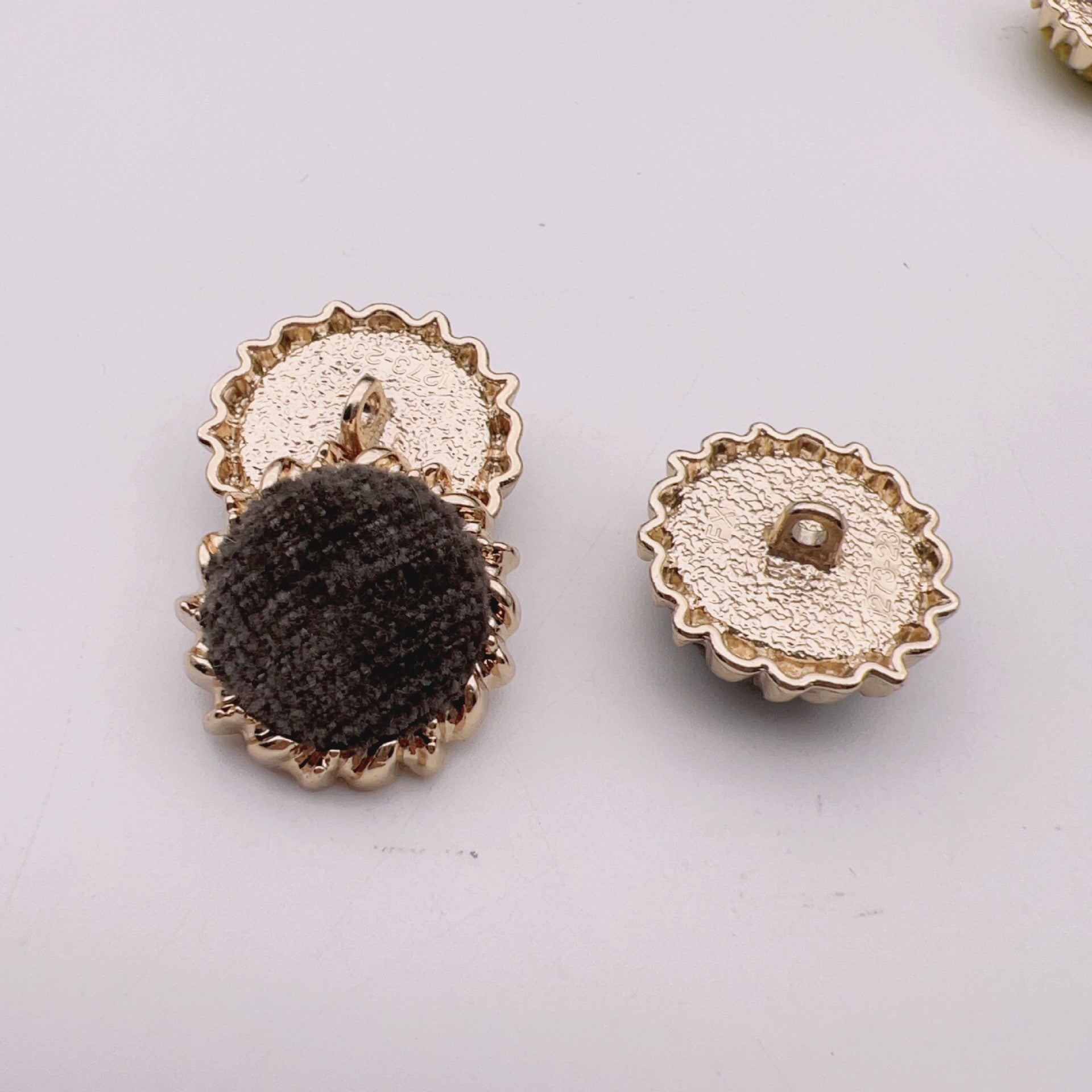 Round velvet fabric buttons, black and white tops with gold-tone gear metal backs.