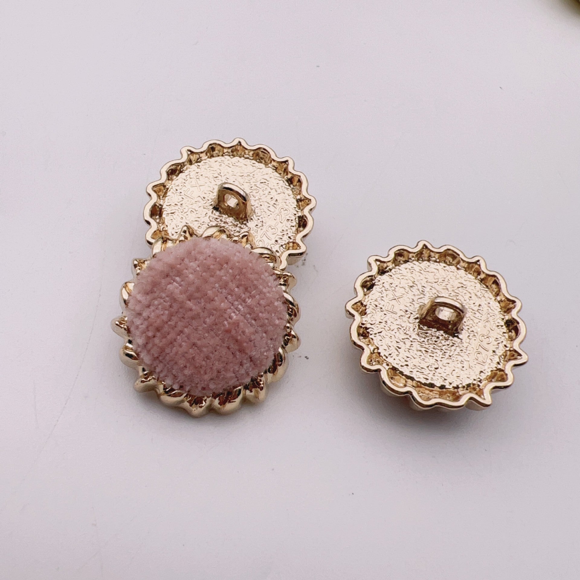 Round velvet fabric buttons, dusty pink and white tops with gold-tone gear metal backs.