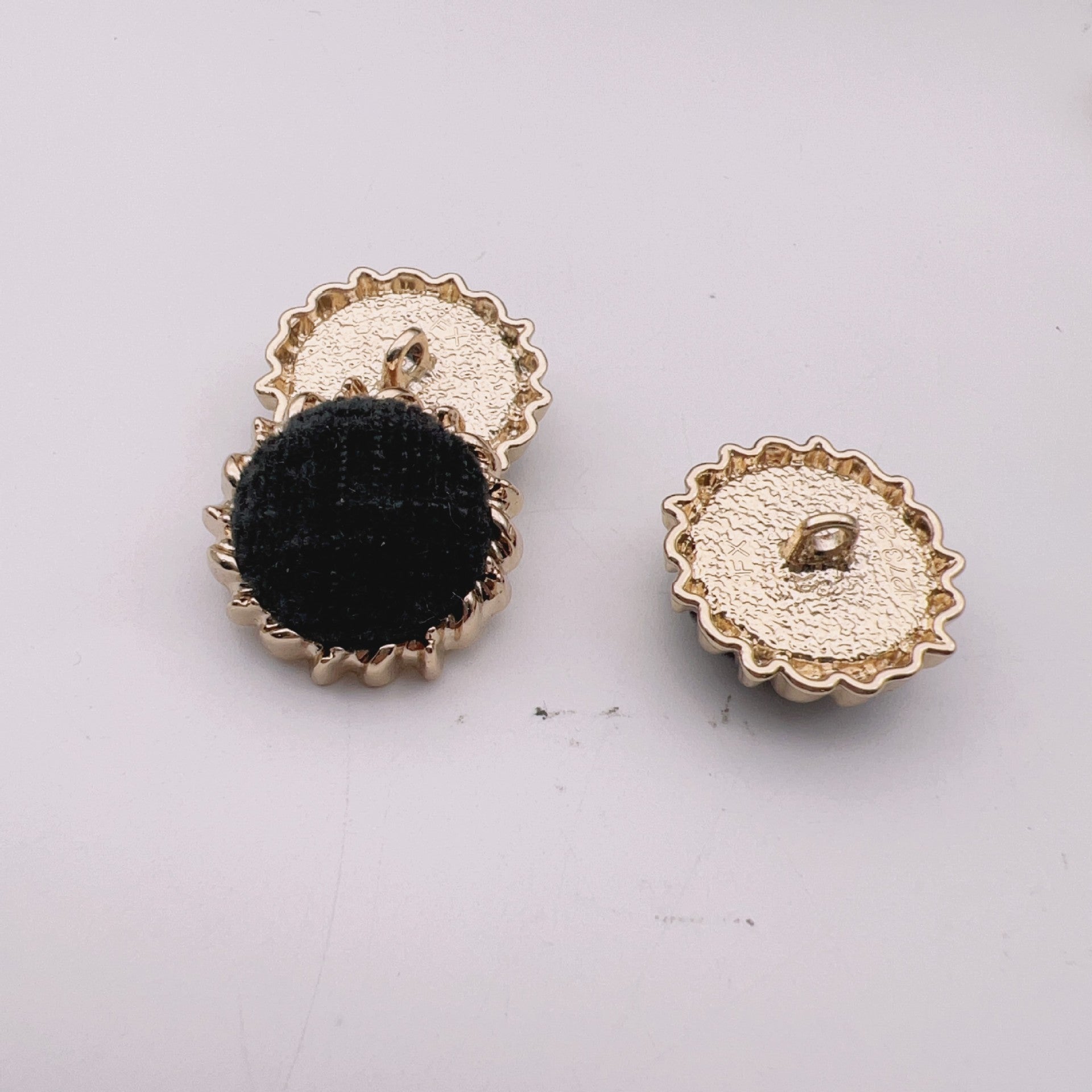 Round velvet fabric buttons, black and white tops with gold-tone gear metal backs.