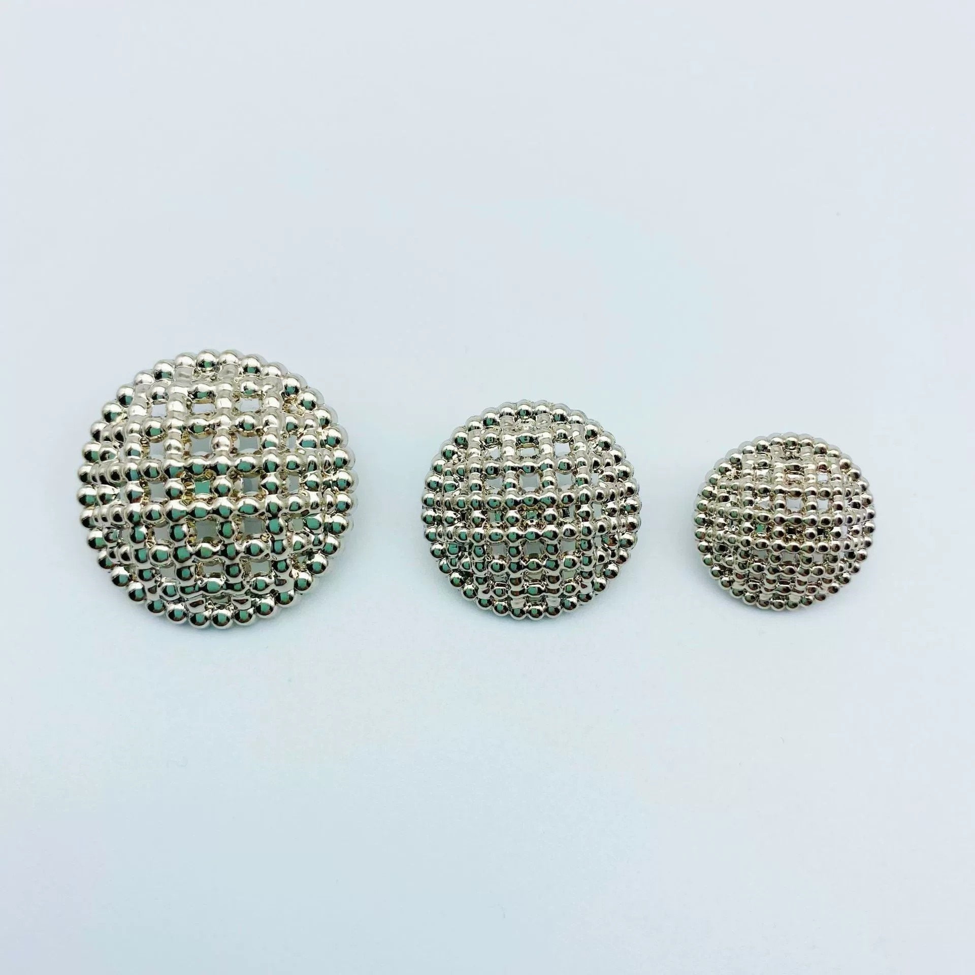 Round hollow-shank metal buttons, silver-tone textured face, three buttons