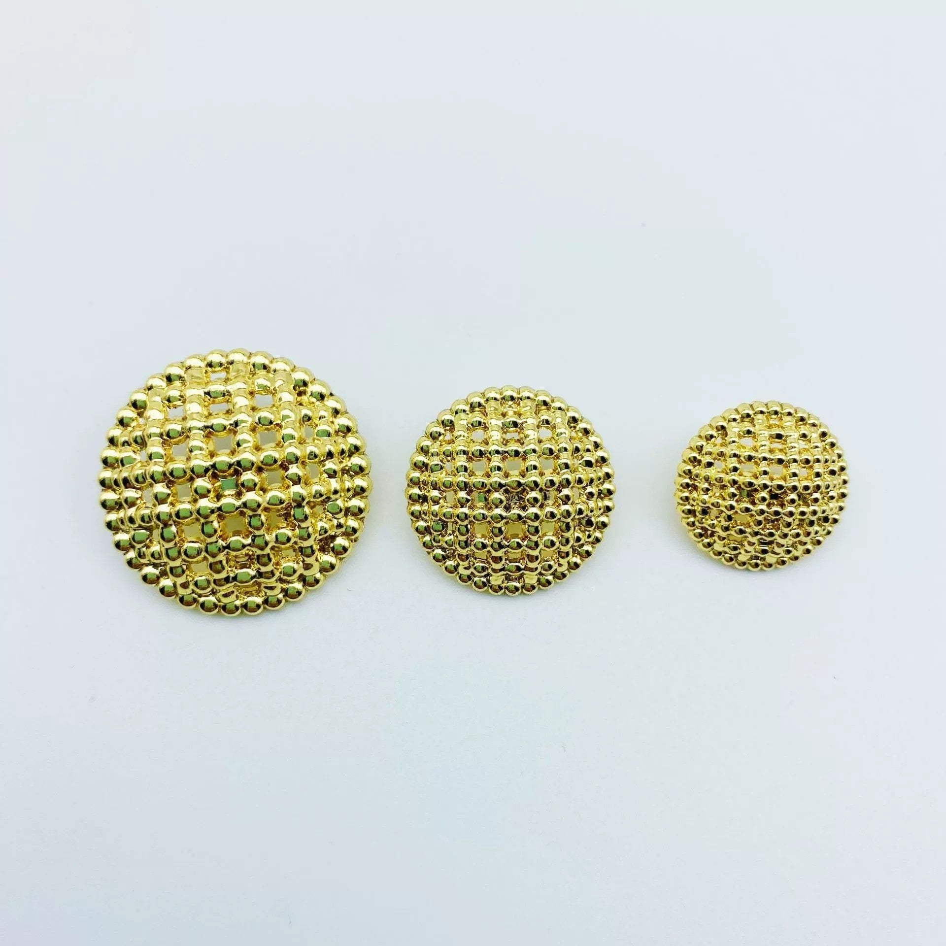 Round hollow-shank metal buttons, gold-tone textured face, three buttons
