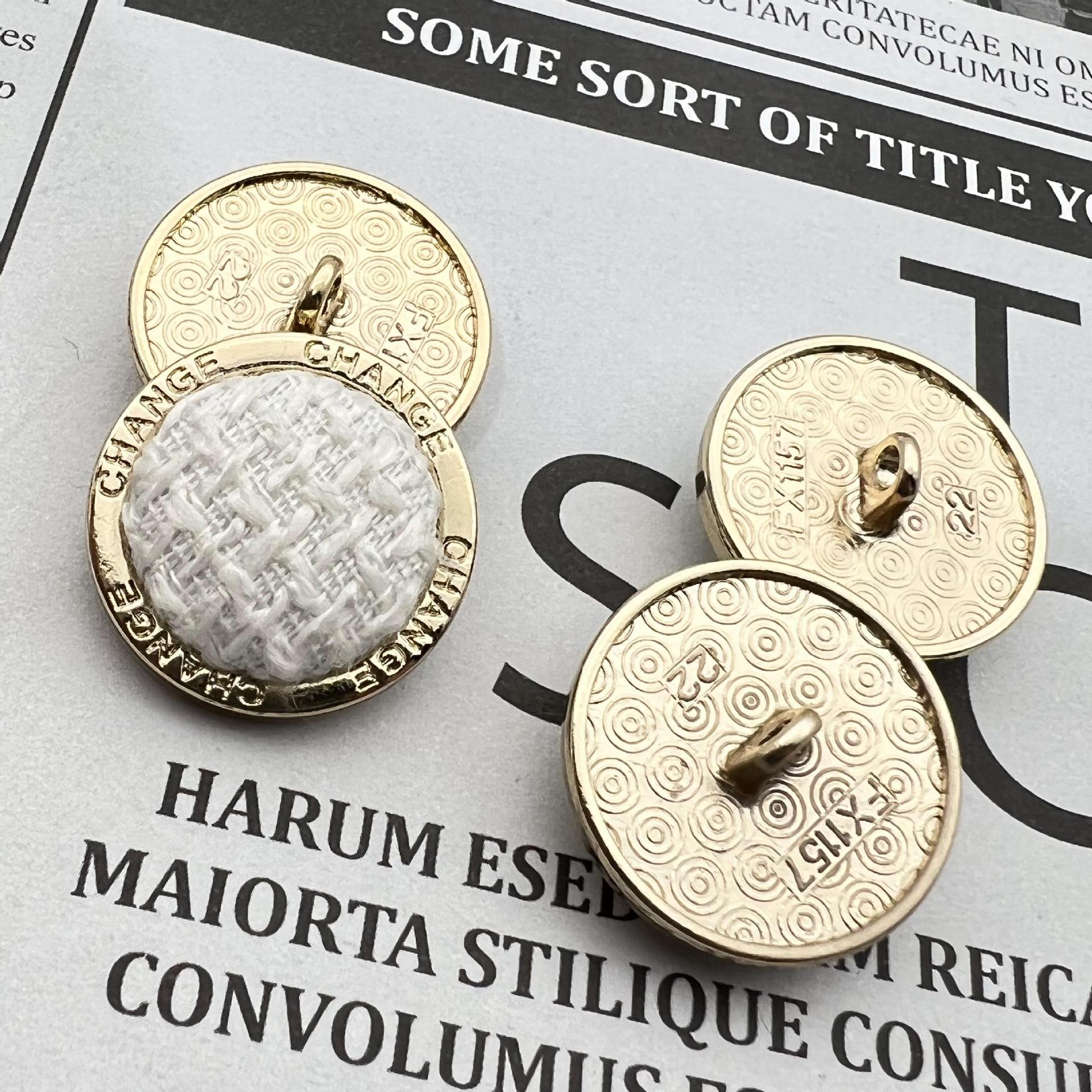 Round metal shank button, gold edge and “CHANGE” text, white knit-look top