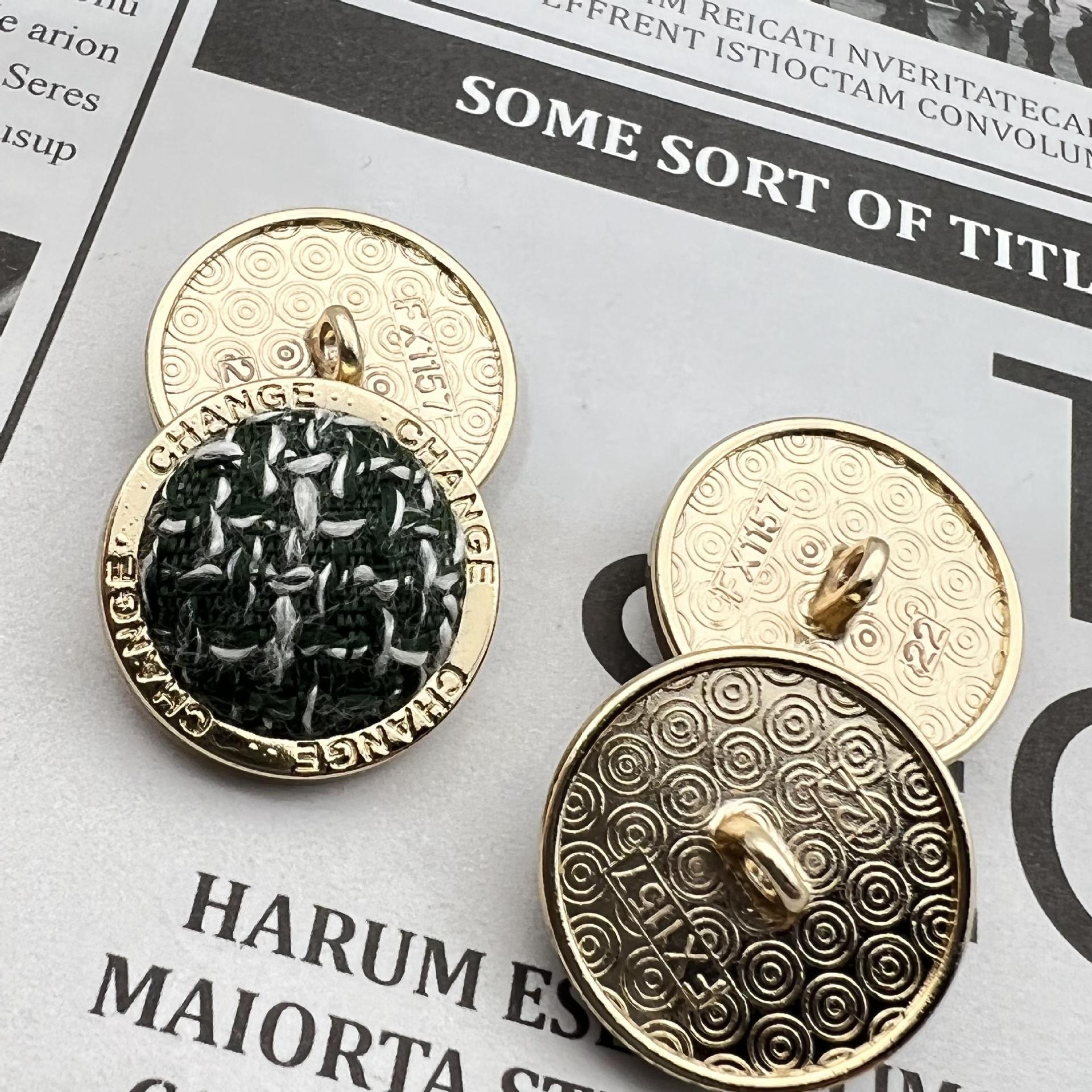 Gold-rimmed metal shank button with “CHANGE” lettering, dark black knit-look center