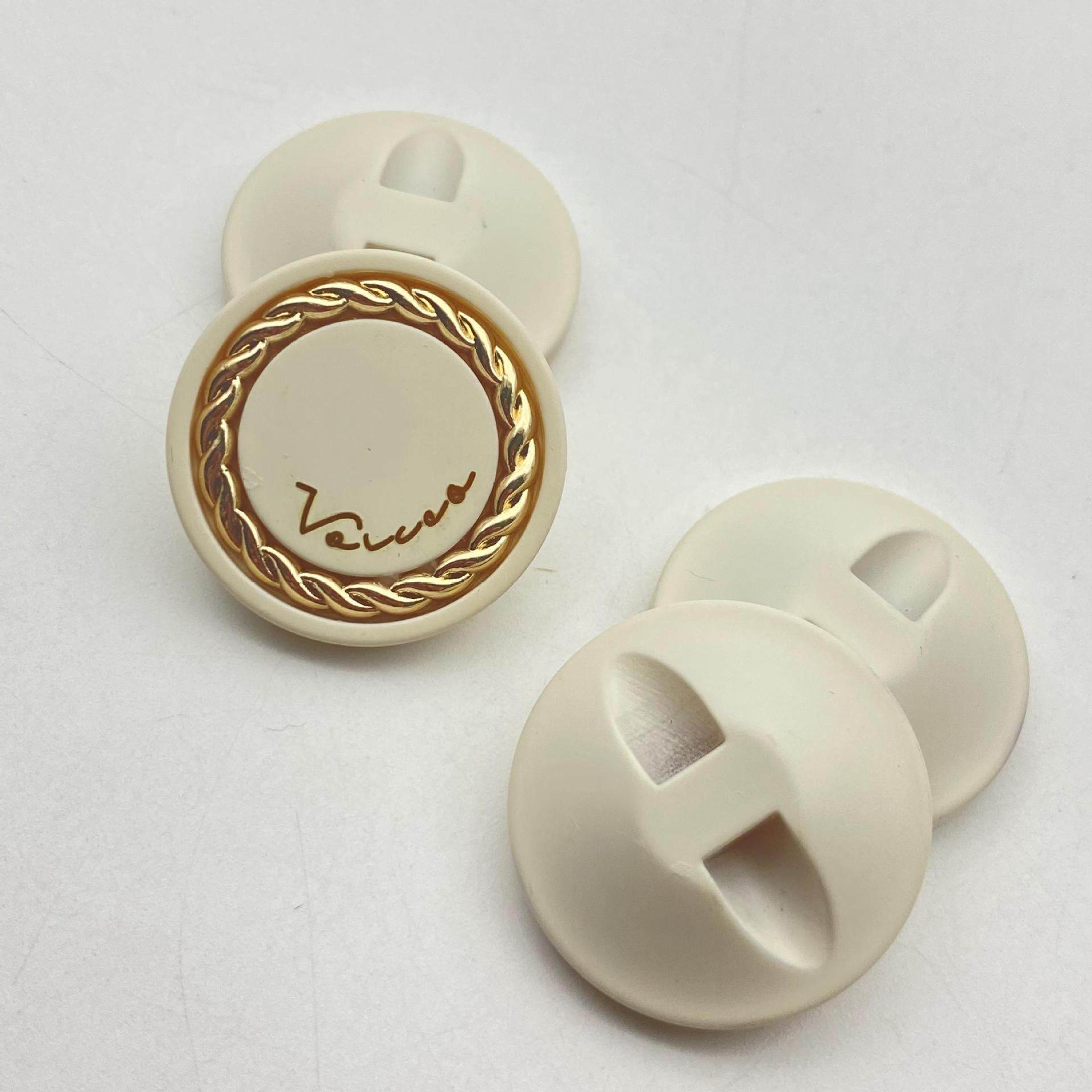 Cream resin button, gold-tone chain mesh rim with scripted center, 25mm hidden shank