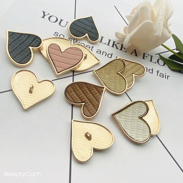 Heart-shaped leather-look button set, black and cream with gold-tone metal shank, 25mm
