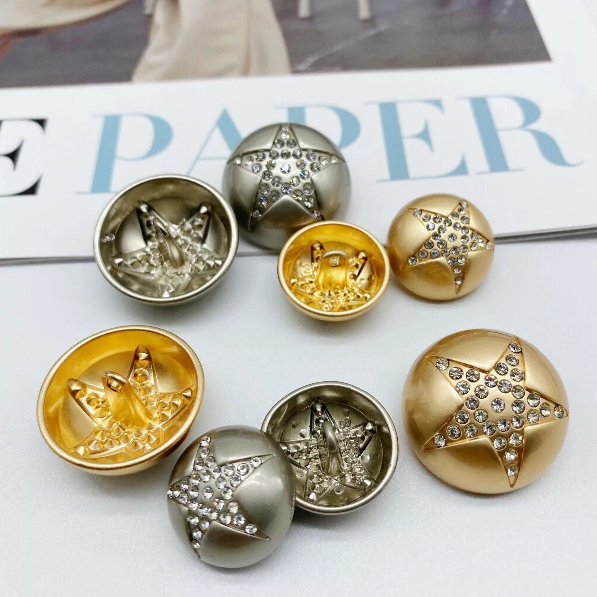 Sew-through star rhinestone mushroom buttons in gold and silver, open backs visible