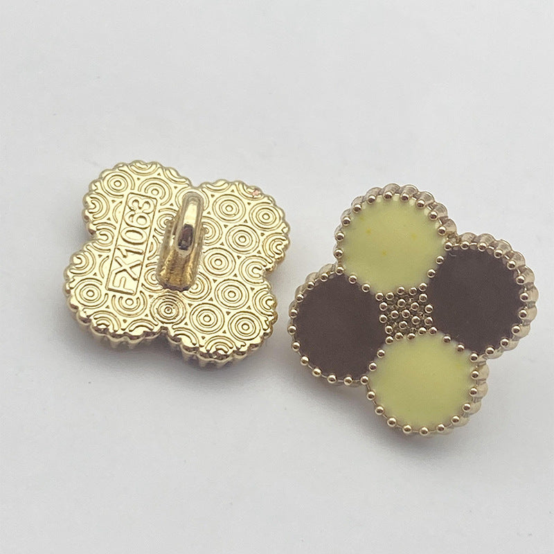 Four-leaf clover shank button pair: gold patterned back with pale yellow and dark bead trim