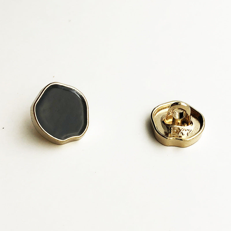 Irregular high-gloss metal shank button with dark face, gold rim, and shank back