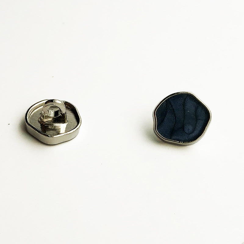 Irregular high-gloss metal shank button with dark blue/black face and silver shank back