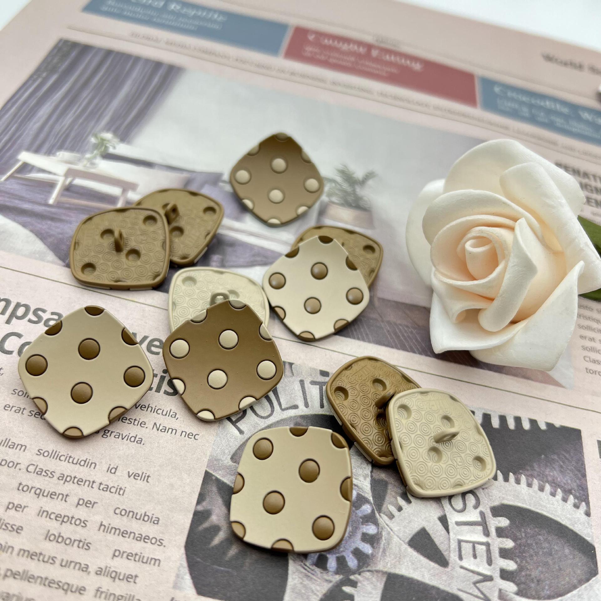 Curved square metal shank buttons with four studs; mix of tan, beige, and dark gray sets