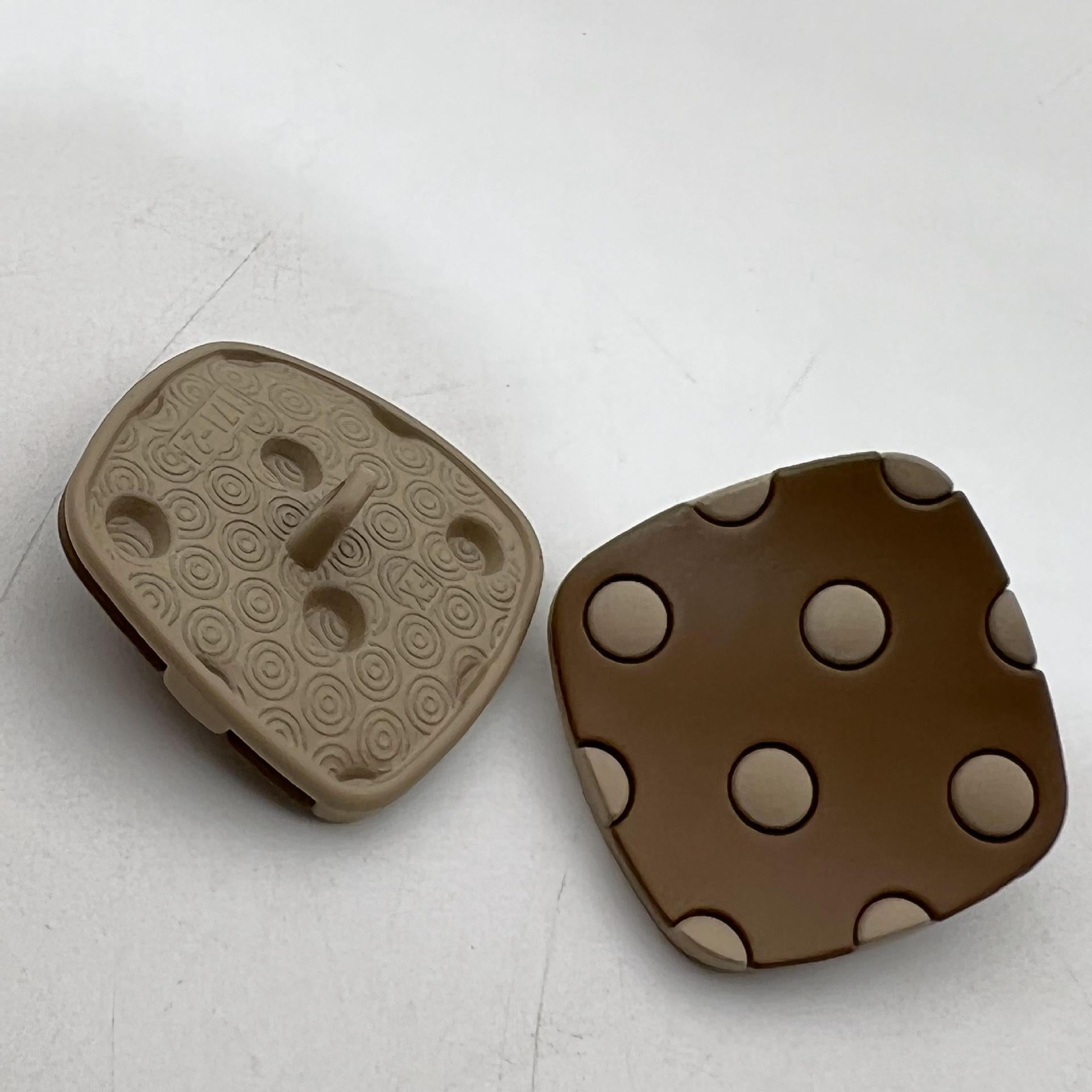 Curved square metal shank buttons with four studs; brown and tan tones