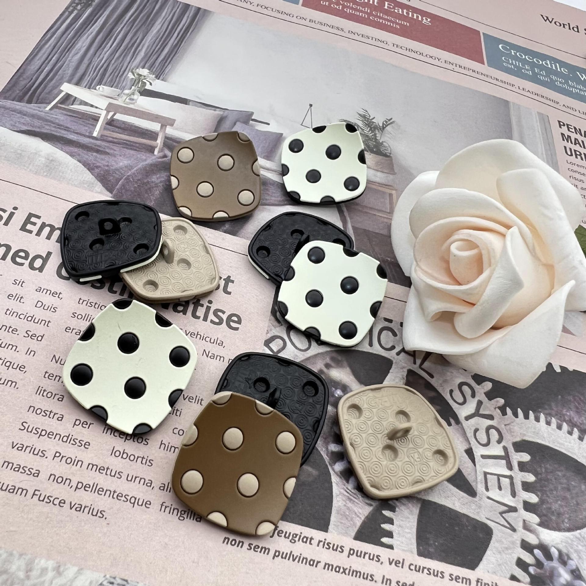 Curved square metal shank buttons with four studs; black, tan, cream, and dark gray tones