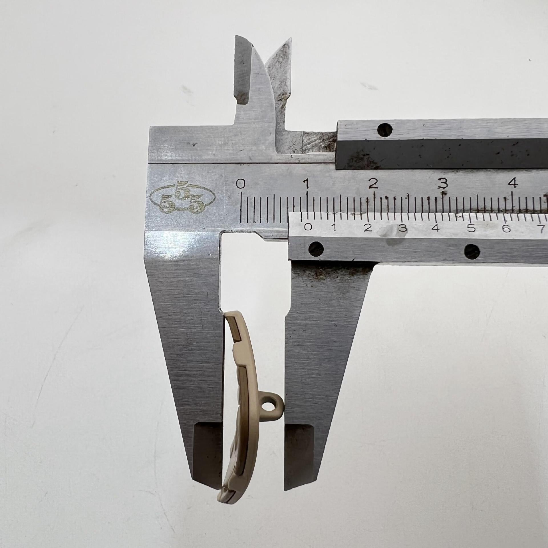 25mm metal shank button with curved square shape and raised studs; side profile