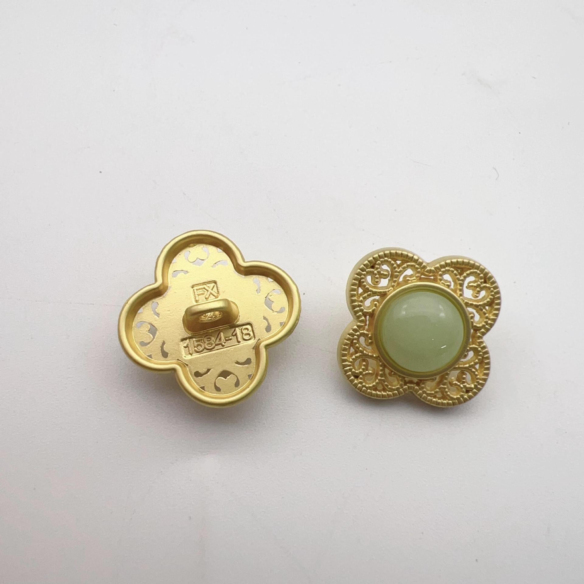 Gold-tone hollow flower shank button, pale green center with decorative filigree border