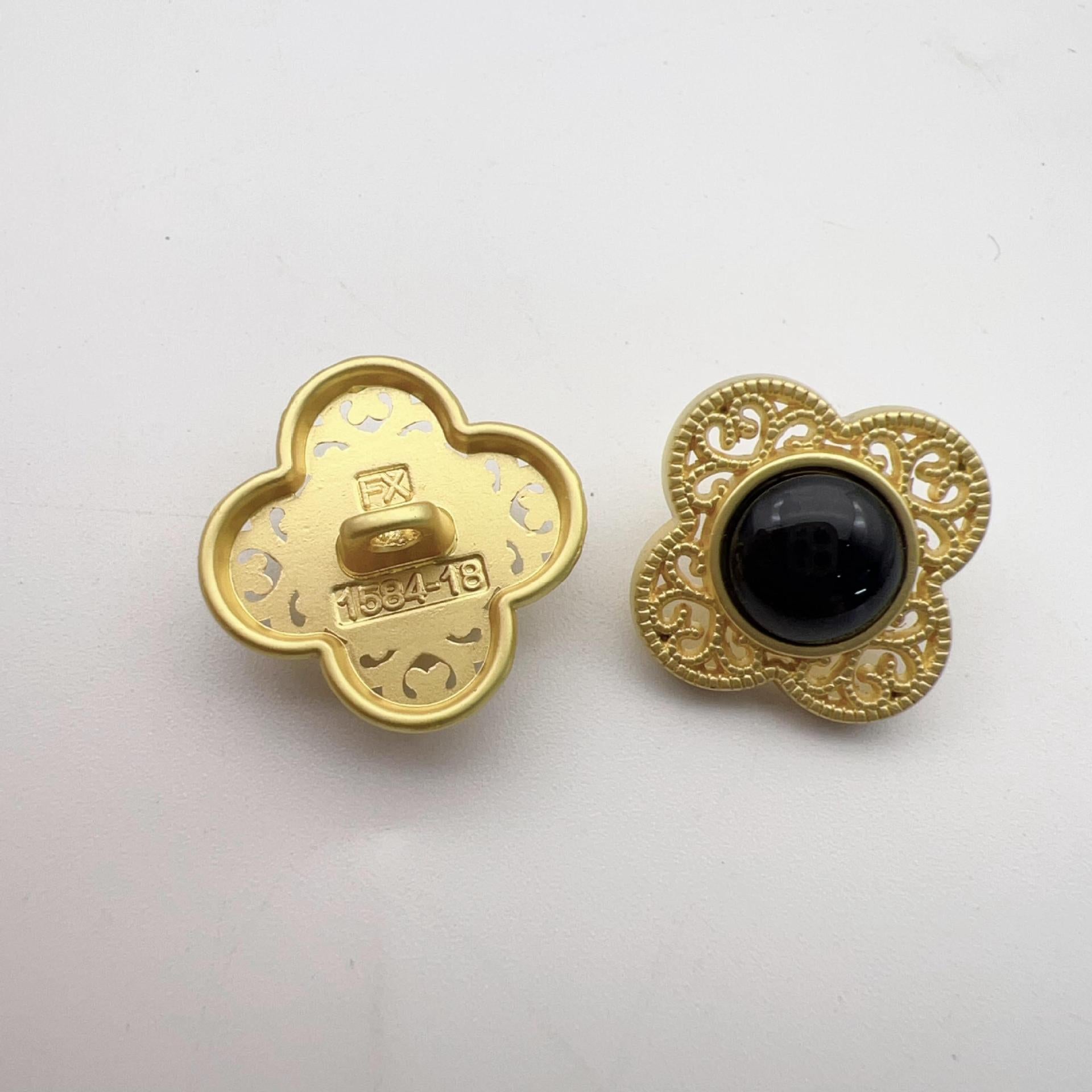 Gold-tone hollow flower shank button, black center with ornate filigree surround