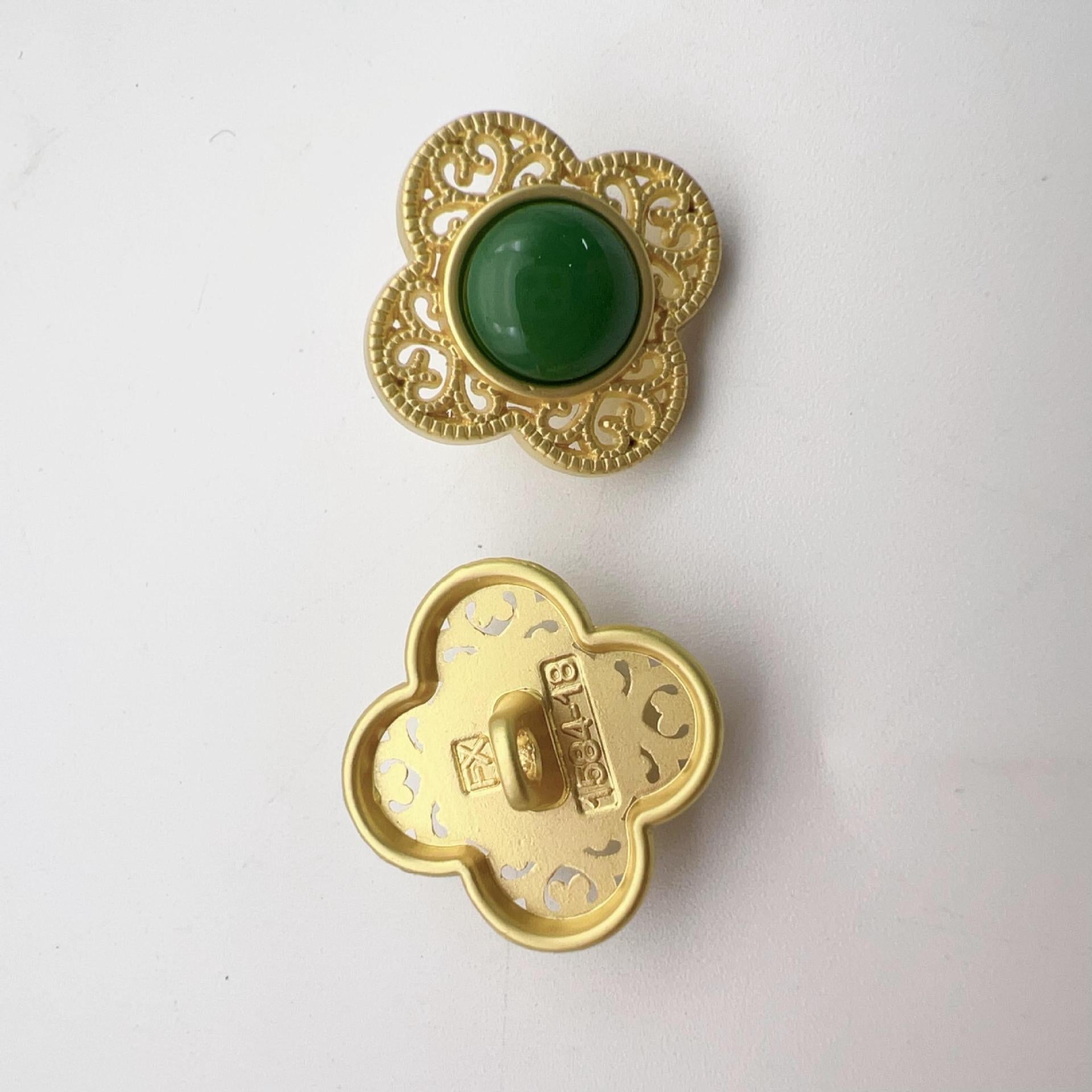 Gold-tone hollow flower shank button, dark green center with ornate lace-like rim