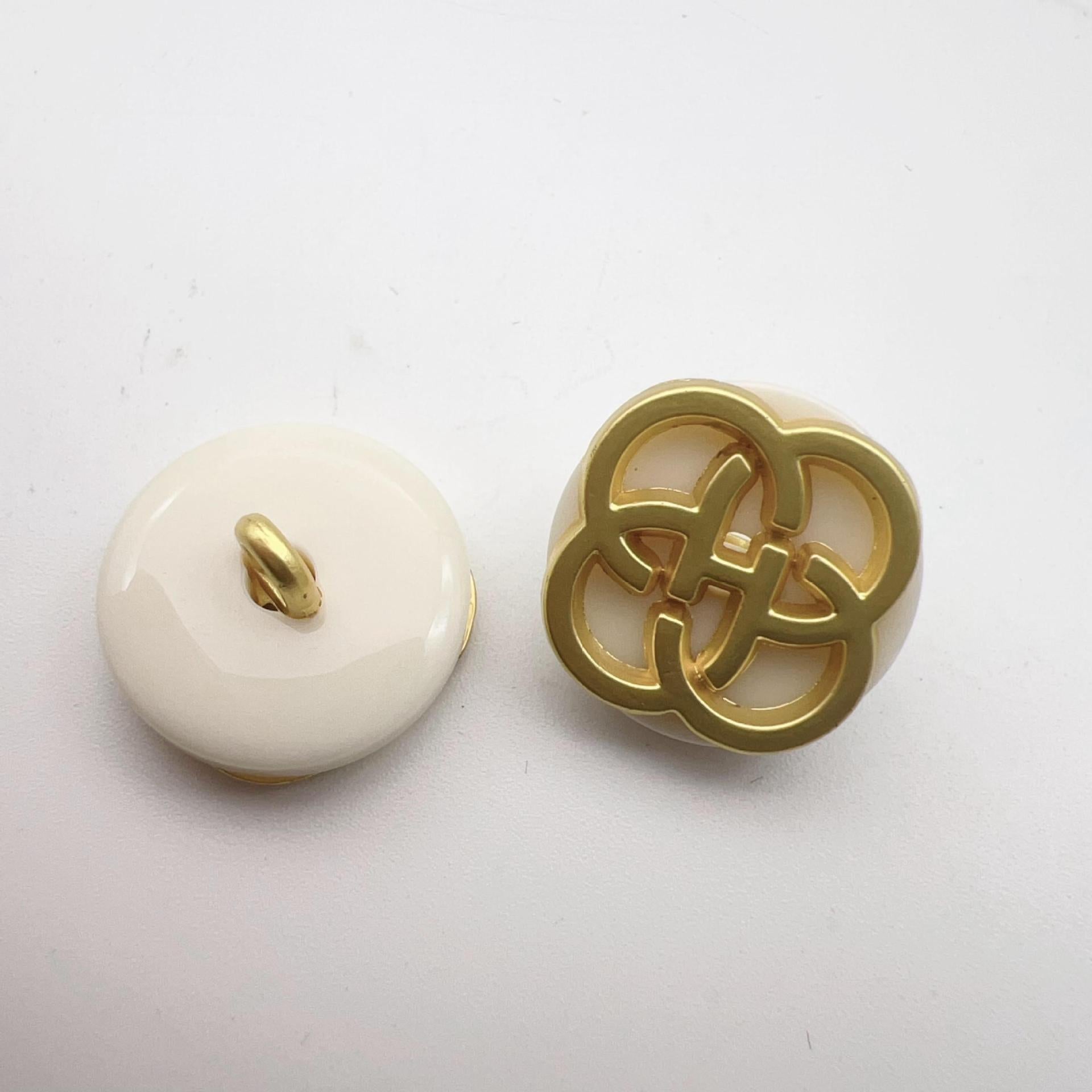 White resin button with gold-tone four-leaf clover shank and raised loop