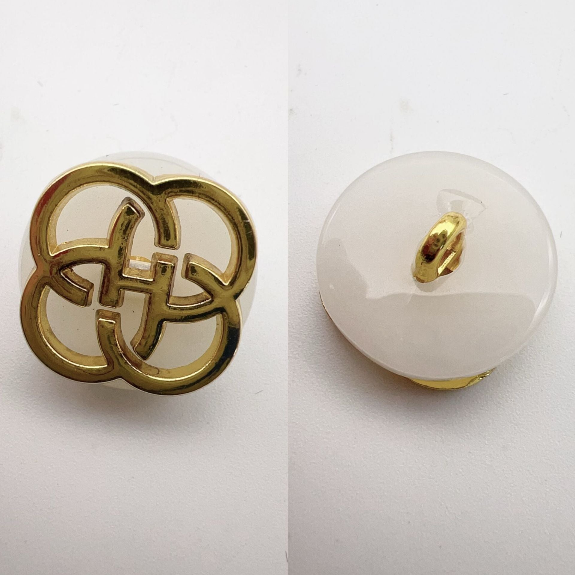 White translucent resin button with gold-tone four-leaf clover shank