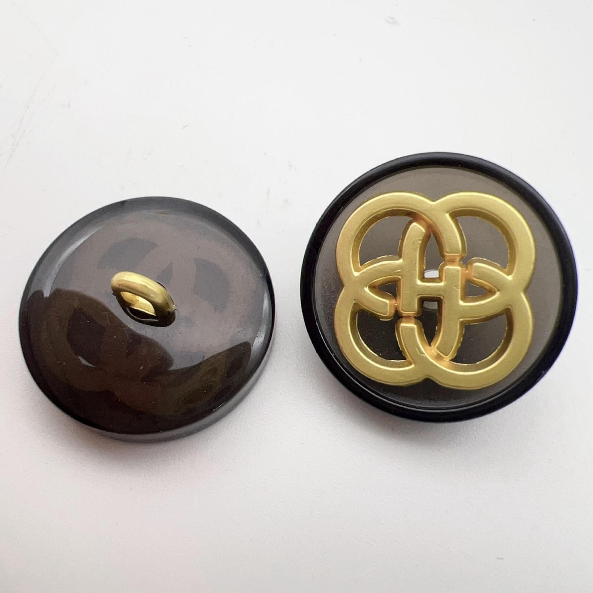 Black resin button with gold-tone four-leaf clover shank and loop
